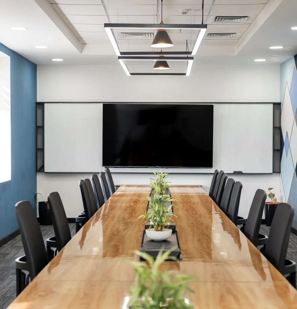 Conference room with a wall-mounted screen and a blue geometric accent wall