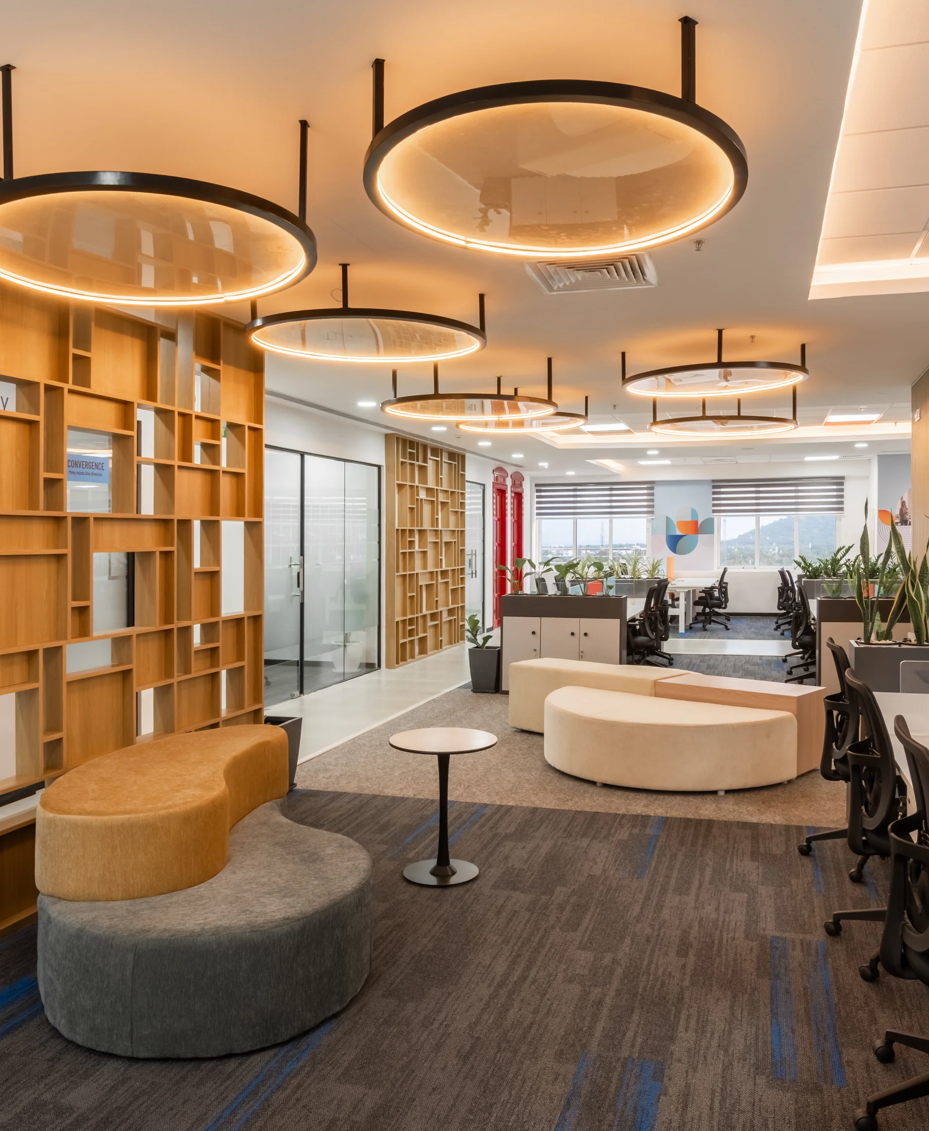 Library and breakout area with timber shelving and circular pendant lights